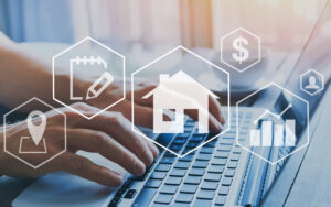 two hands typing on a laptop with images overlaid of a house, dollar sign, graphs, and more. it signifies the array of property management services Riverside AM offers